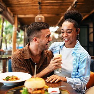 Couple smiling while enjoying meal at restaurant