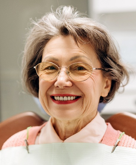 An elderly woman smiling after a dental treatment