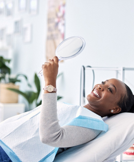 Woman smiling while looking at reflection in mirror