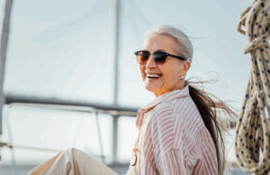 Woman smiling while enjoying the sea breeze on her boat