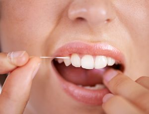 Closeup of someone flossing their teeth